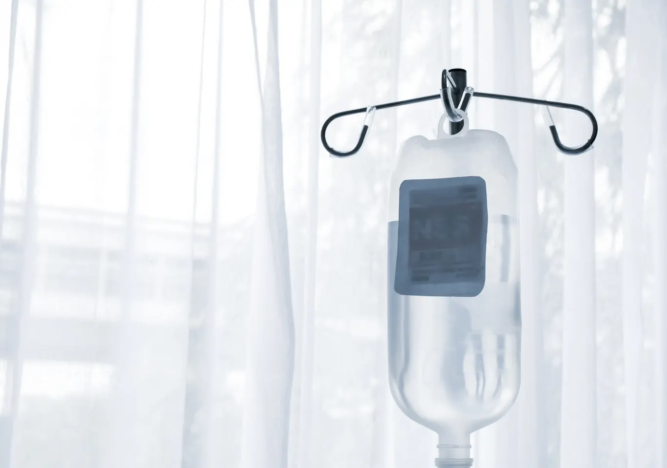 Kroplówki witaminowe Opole: butelka płynu infuzyjnego zawieszona przy oknie