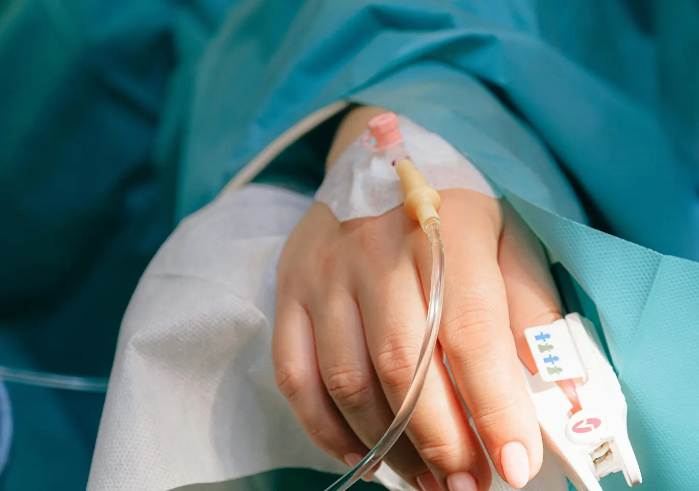 Detoks alkoholowy Opole: dłoń z wenflonem i pulsoksymetrem pod nadzorem
