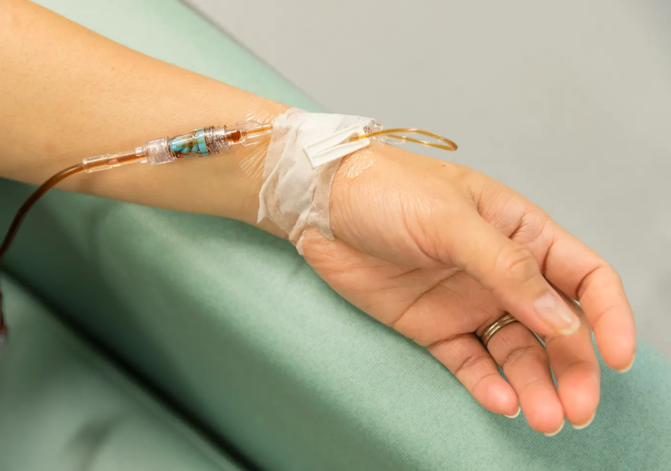 Kroplówki witaminowe Głubczyce: dłoń z wenflonem i linią infuzyjną na podkładzie