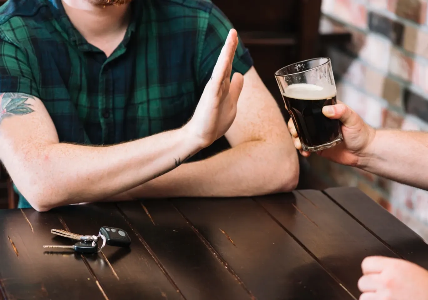 Wszywka alkoholowa Opole - Skuteczne wsparcie w walce z nałogiem: dłoń odmawiająca kufla piwa przy stole